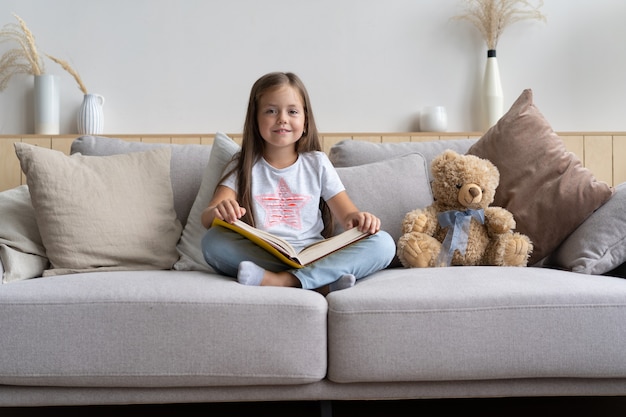 Livre de lecture de jeune fille à la maison. Enseignement à distance, enseignement à domicile. Concept d'auto-isolement.