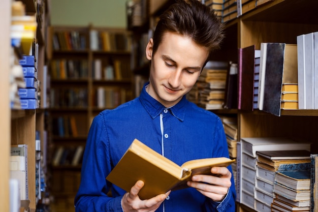 livre de lecture de jeune homme dans la bibliothèque