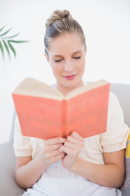 Livre de lecture de modèle frais paisible assis sur le canapé