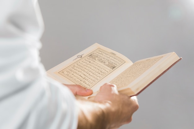 Photo livre musulman religieux tenu dans les mains