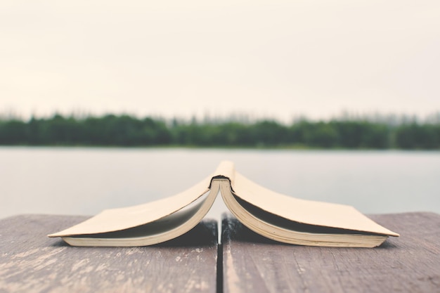 Photo un livre ouvert devant le lac.