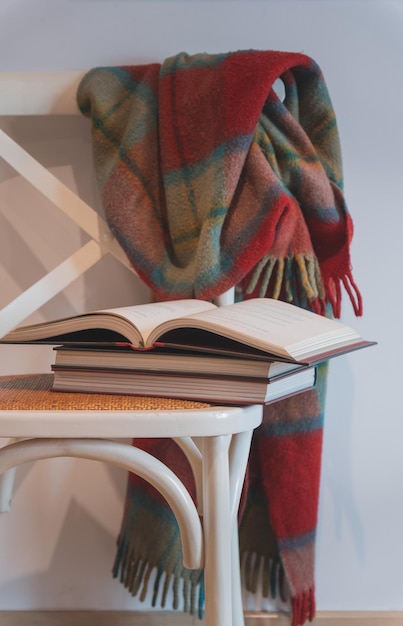 Livre ouvert sur des livres sur une chaise blanche avec couverture