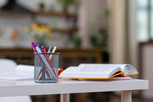 Livre ouvert et stylos sur la table