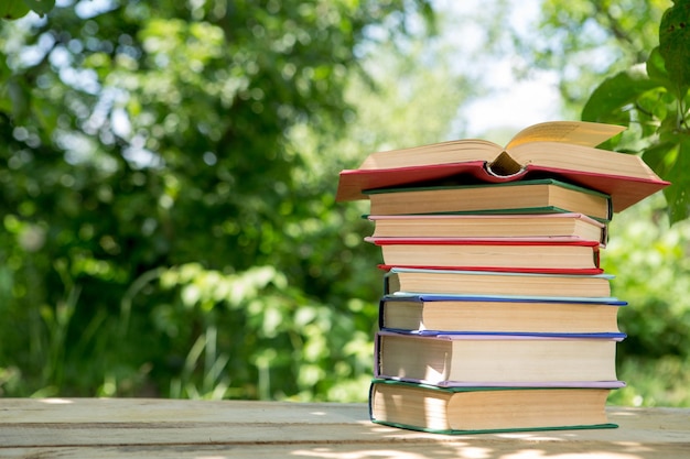 Livre ouvert sur une table en bois dans un jardin Journée d'été ensoleillée lecture dans un concept de vacances