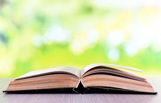 Livre ouvert sur une table en bois sur fond naturel