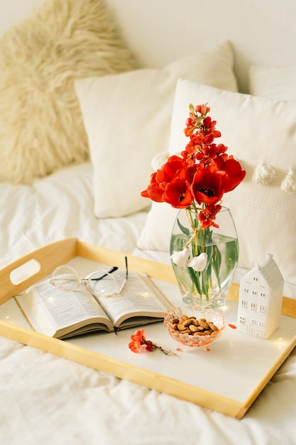 Livre Ouvert Et Vase Tulipes Rouges Sur Un Plateau Sur Le Lit