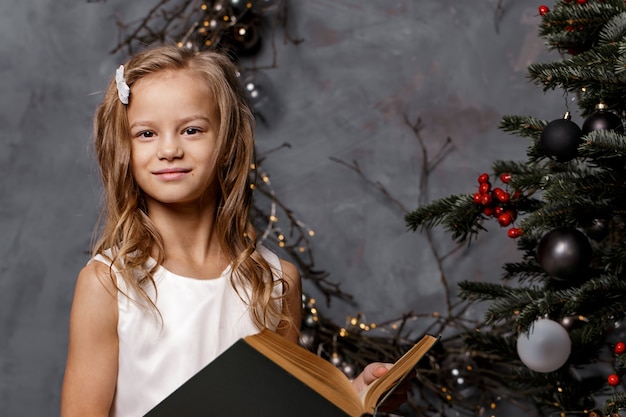 Livre d'ouverture de fille dans la chambre décorée pour Noël