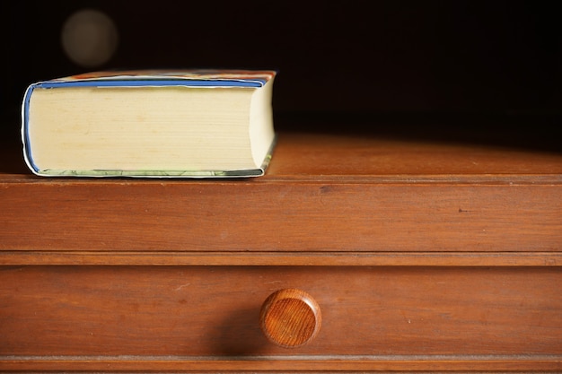 Livre de poche dans une armoire en bois avec un espace pour le texte ou le travail