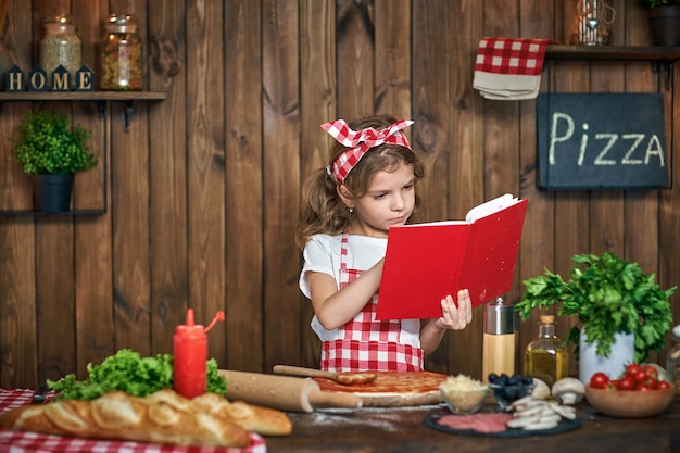 Livre de recettes de lecture jolie fille en tablier à carreaux