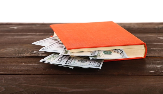 Livre rouge avec des billets en dollars imbriqués sur fond blanc Cachette d'argent