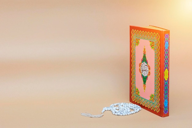 Photo livre sacré de l'islam des musulmans le coran est placé sur la scène brune le coran est une partie importante de l'islam perles placées près
