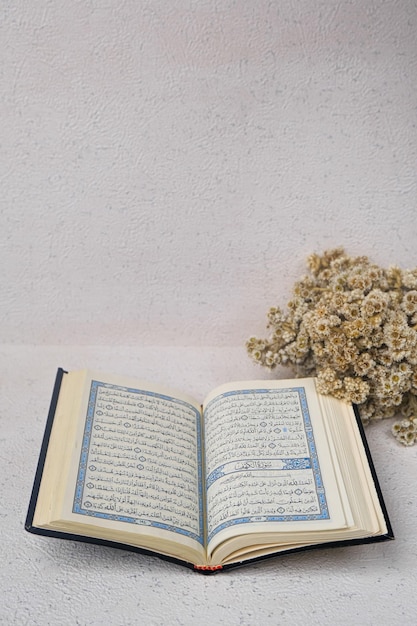 Photo le livre sacré de la religion islamique, le coran avec fleur.