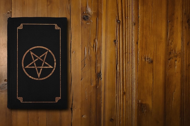 Livre satanique sur un bureau en bois