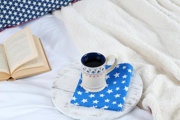Livre et tasse de thé sur le lit agrandi