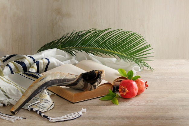 Livre de la Torah shofar tallit grenades et branche de palmier sur une table en bois au soleil Symbole des fêtes israéliennes