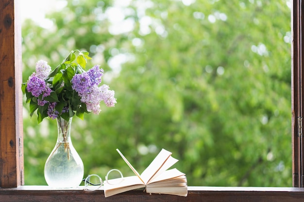 Livre verres et lilas sur une fenêtre en bois Concept romantique Style vintage