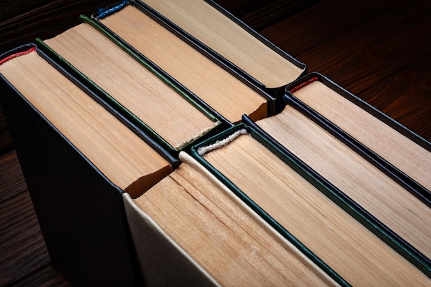 Livres anciens Vieux livres cartonnés fermés utilisés dans la poussière sur fond de bois foncé
