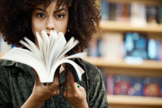 Livres de bourses d'études et étudiante en bibliothèque apprenant à étudier et à lire des connaissances ou des informations éducatives Jeune femme noire intelligente et afro sur le campus universitaire ou collégial avec un roman scolaire