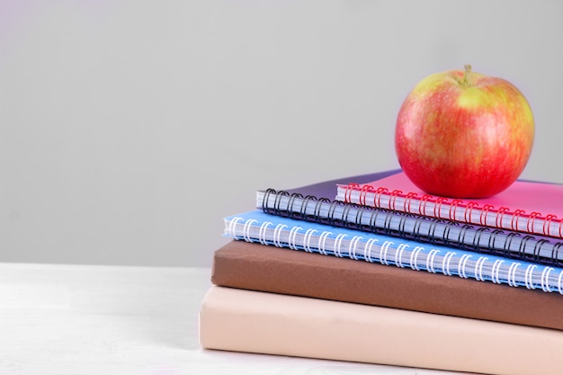 Livres et cahiers avec une pomme