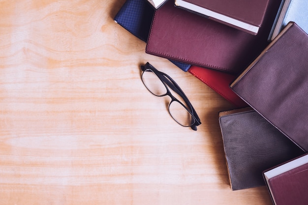 Livres cartonnés avec des lunettes sur la table en bois. Espace libre pour le texte