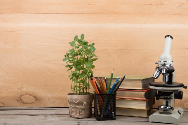 Livres de concept d'éducation et microscope sur le bureau de l'auditorium