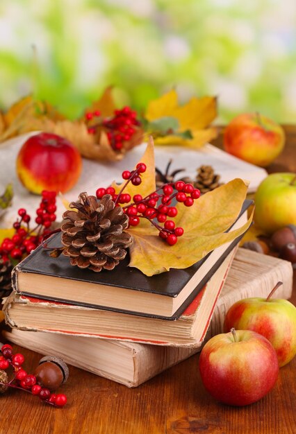 Livres et feuilles d'automne sur une table en bois sur fond naturel