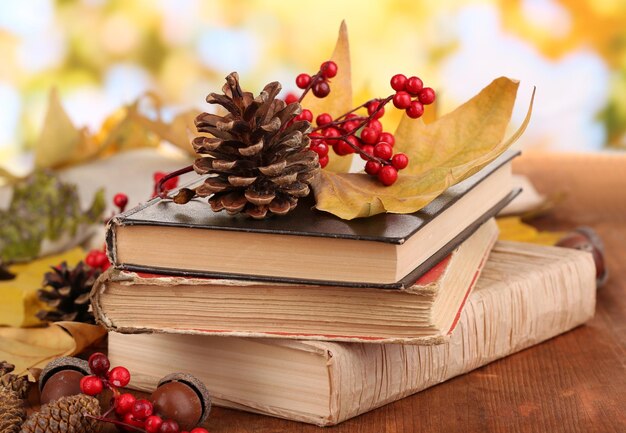 Livres et feuilles d'automne sur une table en bois sur fond naturel