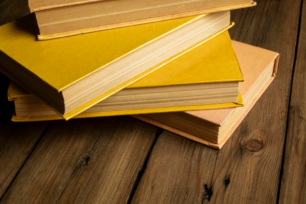 Les livres jaunes se trouvent sur une table en bois Livres pour apprendre sur la table Photo prise sous un angle