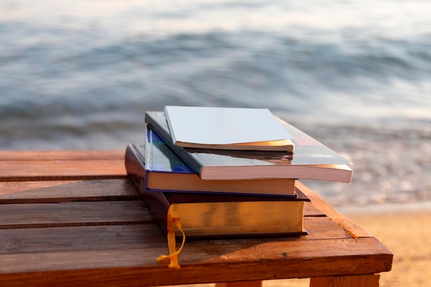 Photo des livres sur la plage au bord de la mer au coucher du soleil concept d'école