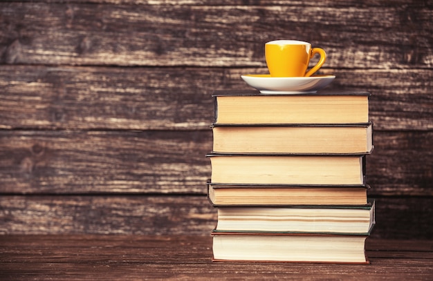 Photo livres et tasse de café sur table en bois