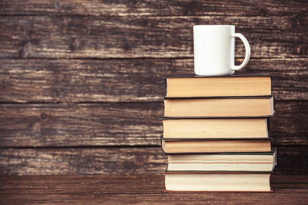 Livres et tasse de café sur table en bois