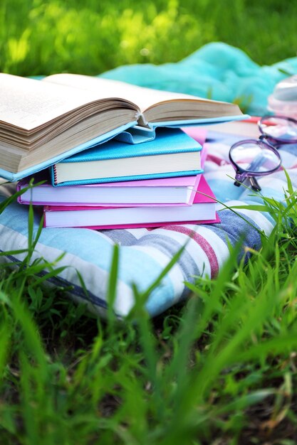 Livres verres et boisson sur l'herbe libre