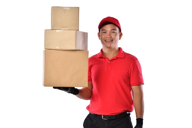 Livreur asiatique en uniforme rouge avec boîte en carton colis isolé sur blanc