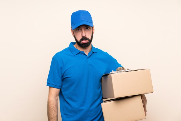 Livreur avec barbe sur un mur isolé avec une expression triste et déprimée