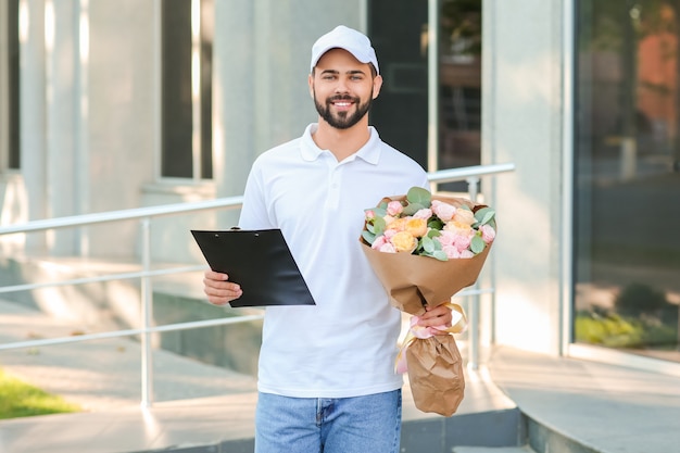 Livreur avec bouquet de belles fleurs à l'extérieur