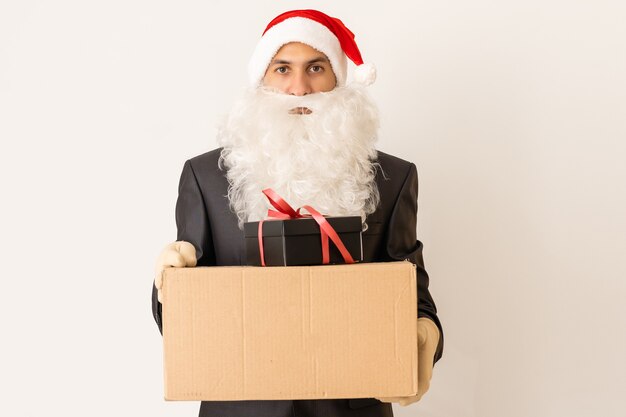 un livreur dans un bonnet de Noel offrant un cadeau avec un arc - isolé