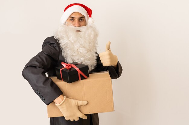 un livreur dans un bonnet de Noel offrant un cadeau avec un arc - isolé