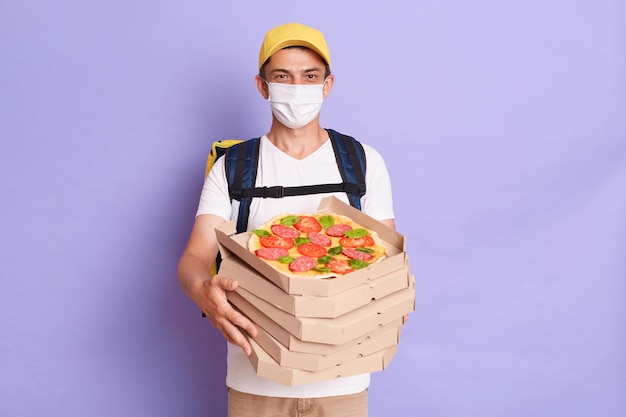 Livreur Dans Un Masque De Protection Tenant Des Boîtes à Pizza Isolées Sur Fond Violet Livrant Des Commandes Aux Clients Service Pendant La Quarantaine Grippe Pandémique Du Virus Du Coronavirus