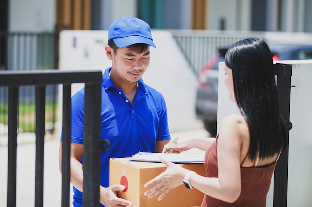 Livreur dans un t-shirt bleu tenant une boîte en carton