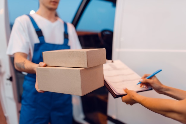 Photo le livreur donne un colis à une destinataire