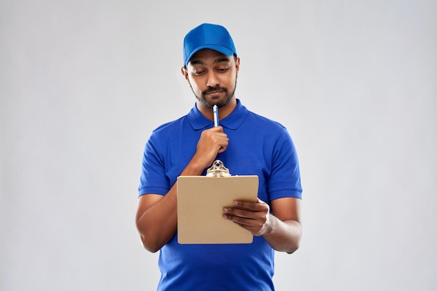 Photo un livreur indien avec un bloc-notes en bleu.