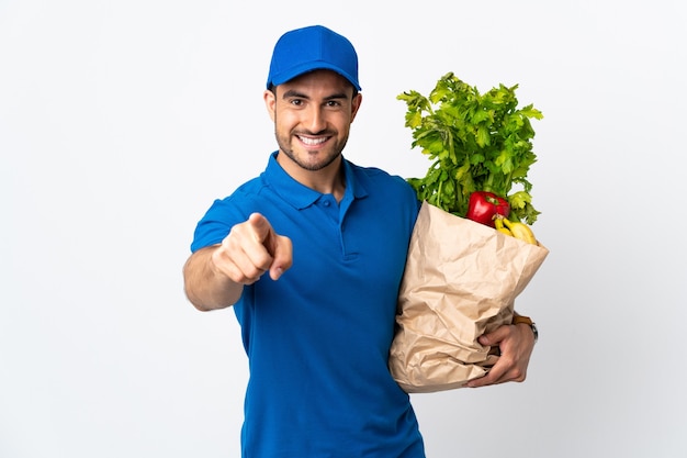 Livreur de légumes isolé sur blanc pointe du doigt vous avec une expression confiante