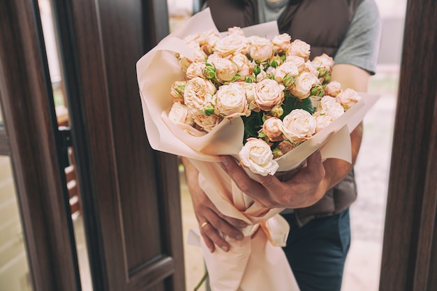 Le livreur livre un bouquet de belles fleurs à domicile