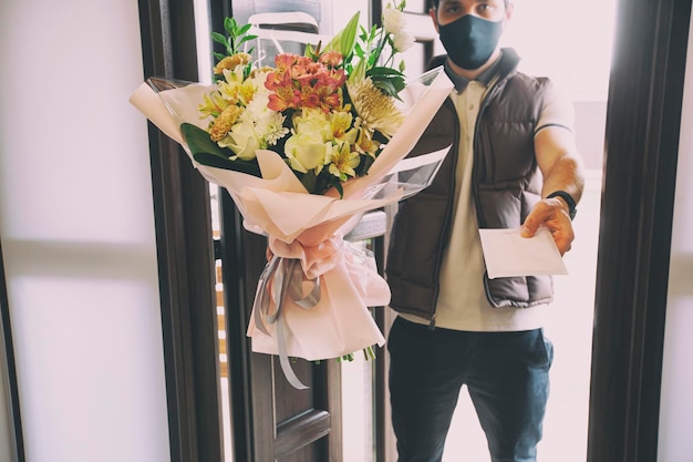 Le livreur livre un bouquet de belles fleurs à la maison