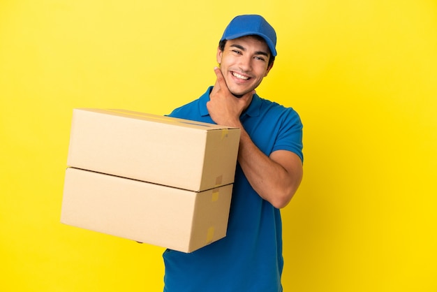 Livreur sur mur jaune isolé heureux et souriant