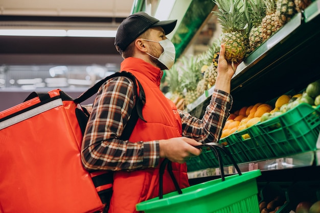 Livreur de nourriture achetant des produits à l'épicerie