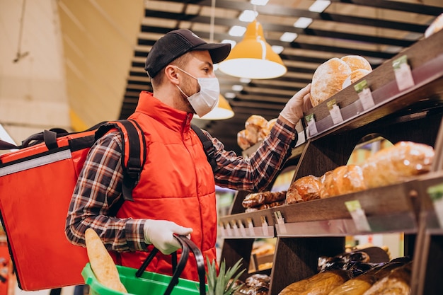 Livreur de nourriture achetant des produits à l'épicerie