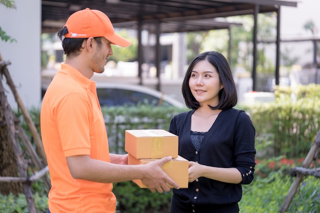 Livreur en orange remet des colis à une femme