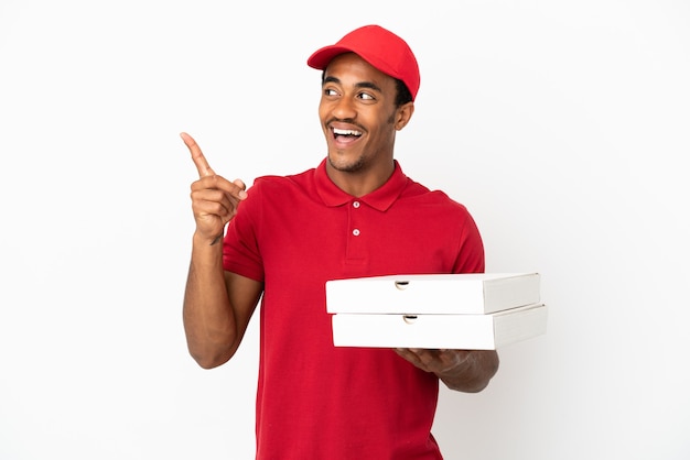 Un livreur de pizza afro-américain ramassant des boîtes de pizza sur un mur blanc isolé dans l'intention de réaliser la solution tout en levant un doigt vers le haut