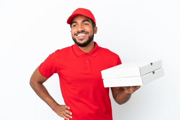 Livreur de pizza ramasser des boîtes de pizza isolés sur fond blanc posant avec les bras à la hanche et souriant